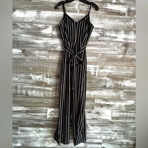 Women’s jumpsuit, black with white pin stripes, and spaghetti straps.
